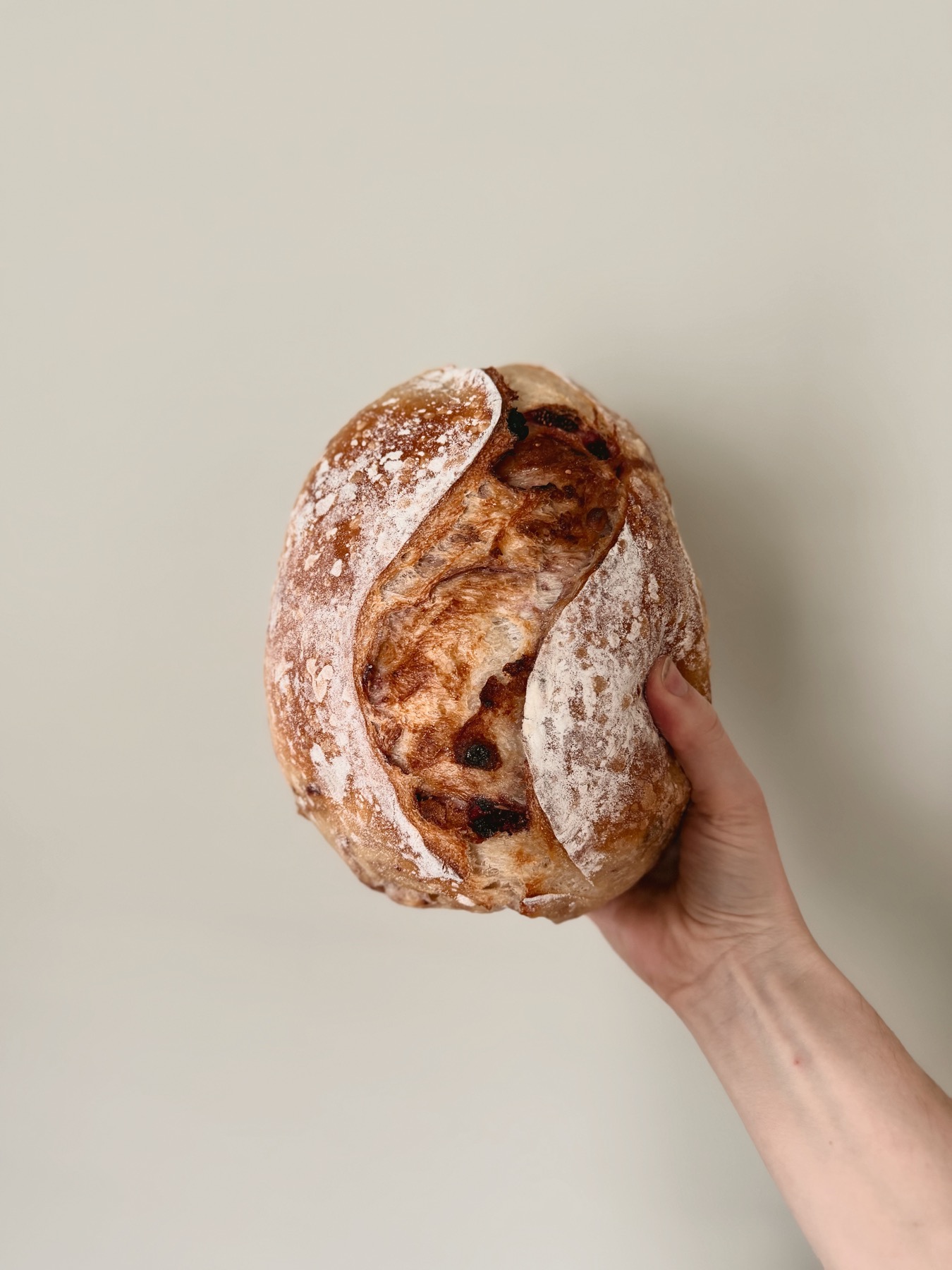 A fresh Lee's Sourdough Co. loaf held by hand
